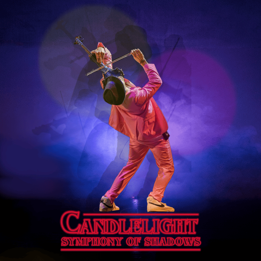 Performer playing guitar with dramatic shadow effects on stage.